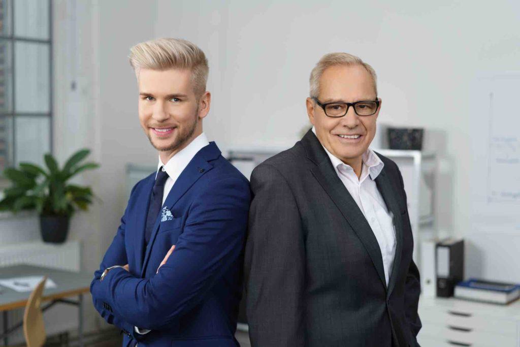 Vater und Sohn stehen im Unternehmen Rücken an Rücken