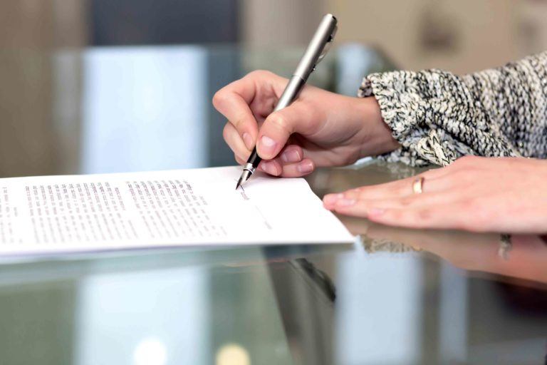 Frau unterzeichnet ein Erbausschlagung Formular